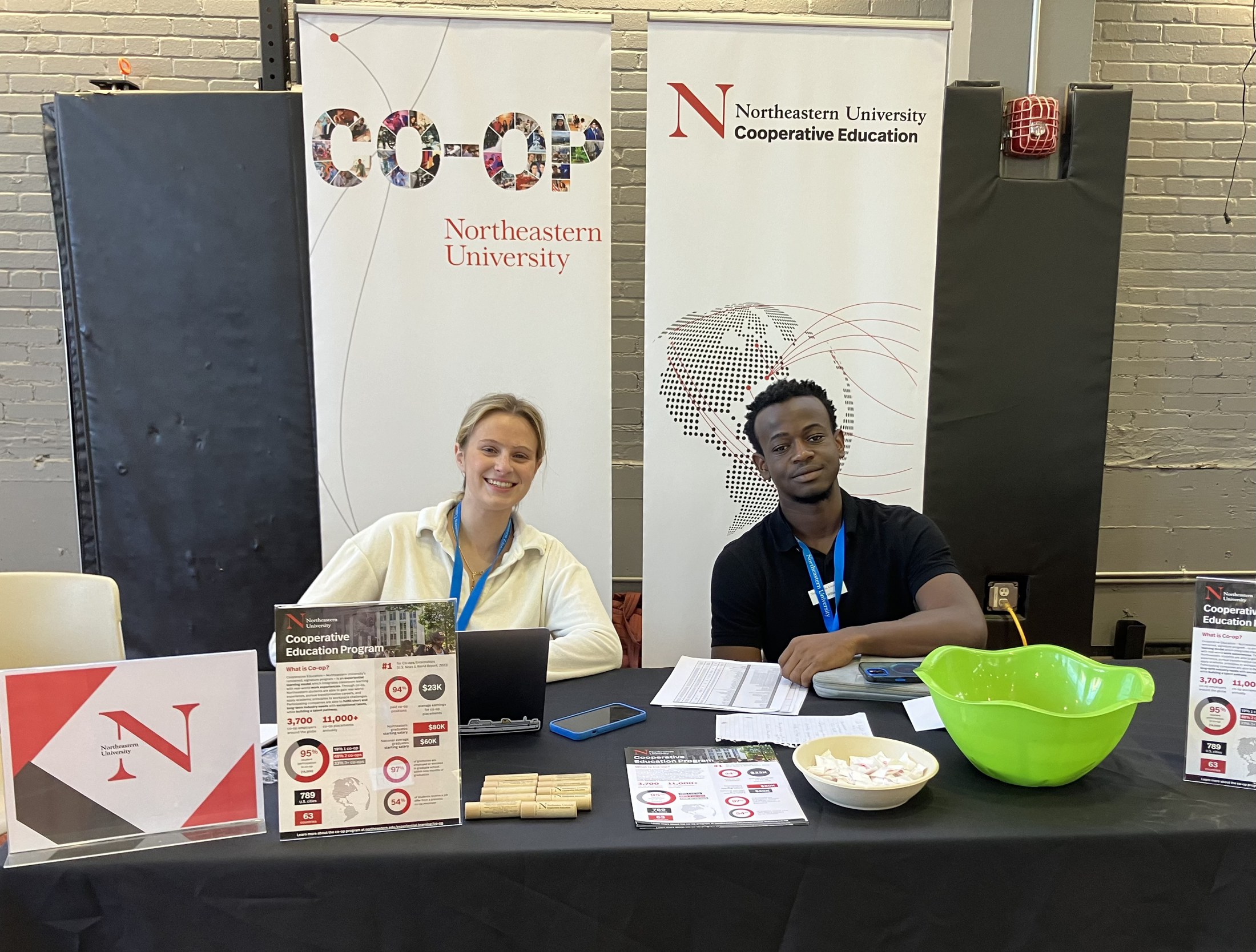A Central Co-op recruiting table with both roll-up banners standing behind it and printed Cooperative Education Program one-pagers on easels